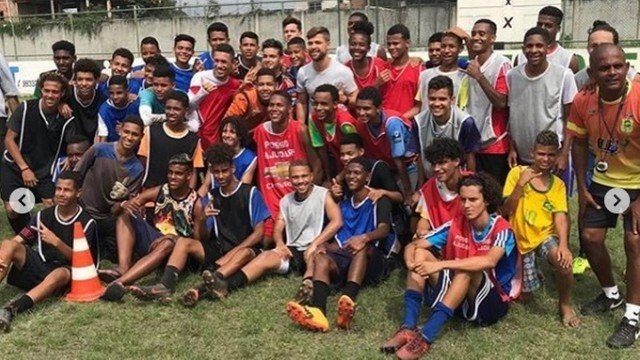 Fora de jogo do Flamengo, meia Diego visita projeto social em Padre Miguel e doa chuteiras